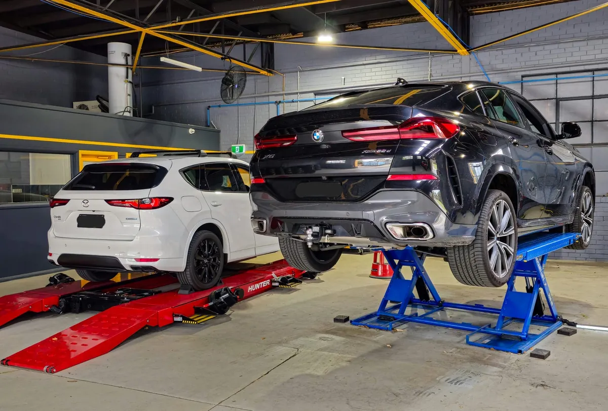 BMW X6 and SUV on hoists in the Tyre Doctors workshop
