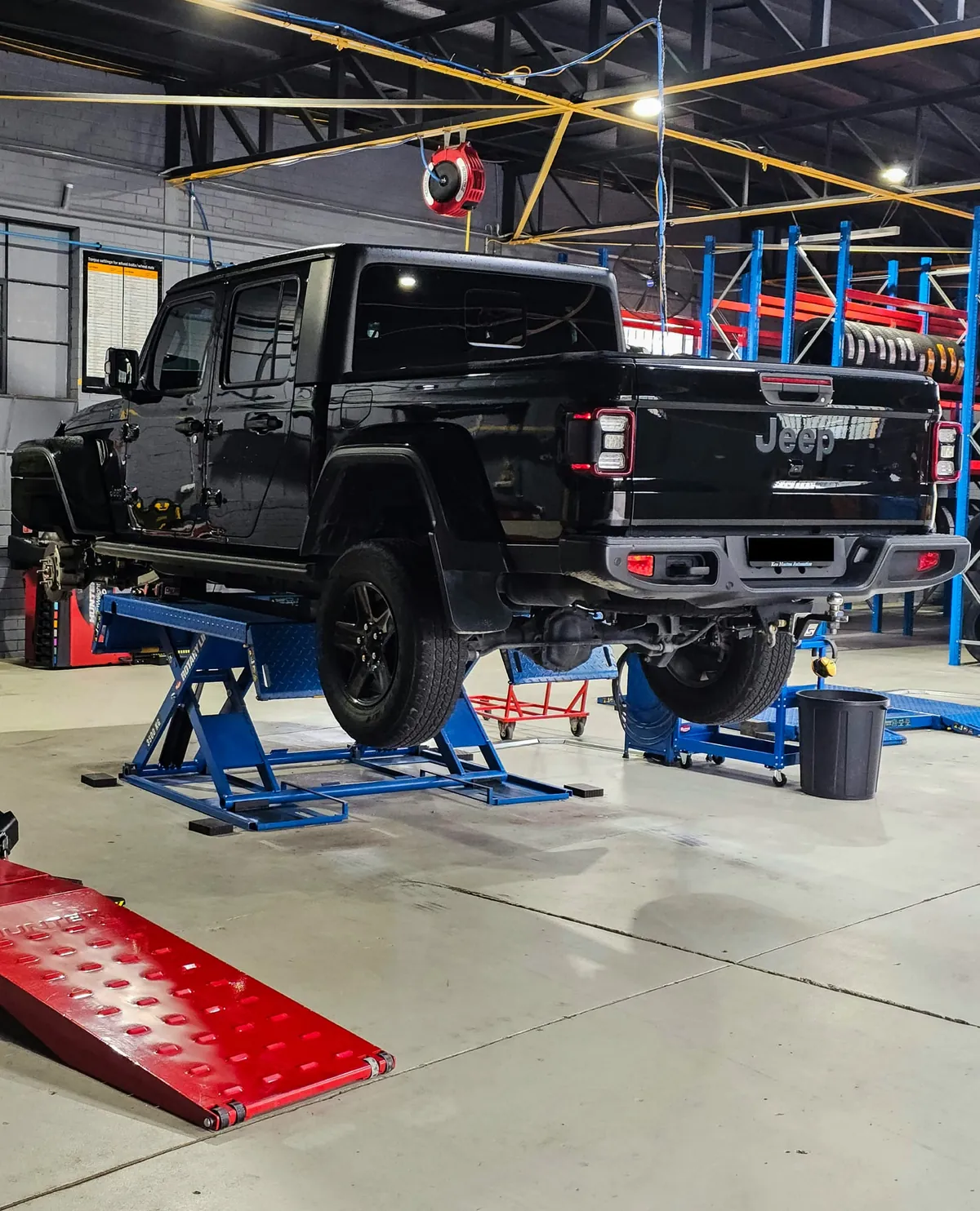 Black dual-cab ute on the hoist for tyres at Tyre Doctors